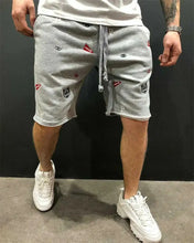 Side walking view of gray cotton-poly shorts with playful embroidery.