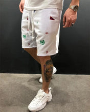 Side walking view of white embroidered Bermuda shorts in relaxed fit.