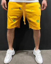 Front view of yellow embroidered Bermuda shorts with mid-waist fit.