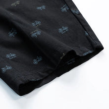 Clean bottom hem stitching detail – black Bermuda shorts.
