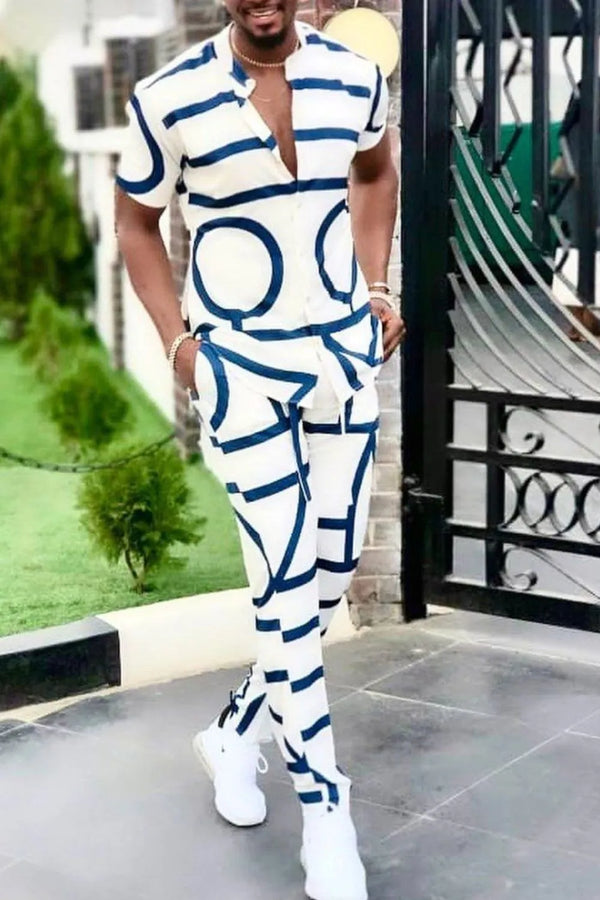 Men's white Drevion GeoSet Luxe short sleeve top and pants set styled with white sneakers in front of a modern mansion.