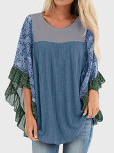 Model wearing BlossomEase Blouse in dusty blue with floral sleeves and relaxed fit.