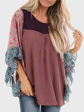 Woman wearing BlossomEase Blouse in dusty pink with floral sleeves and relaxed fit.