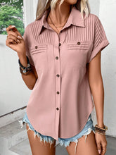 Model wearing a dusty pink pleated collared neck short sleeve blouse with button-up front, paired with light denim jeans, styled for a casual day out.