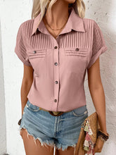 Side profile of model in a dusty pink pleated collared neck blouse with cuffed sleeves, styled with gold hoop earrings and neutral sandals.