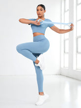 Model stretching with resistance band in Light Blue EroVital Fusion Active Set.