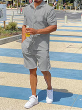 Light gray short sleeve button-up shirt and shorts set, front view on model at a recreation center.
