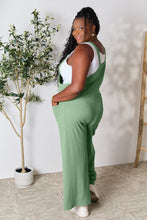 Back view of model in Gum Leaf Cyrella Muse Overalls, highlighting adjustable straps.