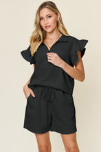 Facts Only Fit Texture Shorts Set in black, front view laid flat showing half-zip flounce sleeve top and drawstring shorts
