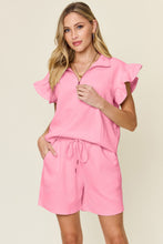 Facts Only Fit Texture Shorts Set in carnation pink, front view laid flat showing half-zip flounce sleeve top and drawstring shorts