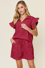 Close-up of textured fabric, half zip, drawstring, pockets, and flounce sleeve detail on Facts Only Fit Set in deep red.
