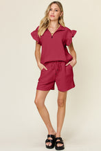 Model walking in deep red Facts Only Fit Set, paired with heels for a casual-chic look.