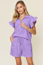 Model walking in lavender Facts Only Fit Set, paired with heels for a casual-chic look.