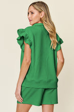 Back view of model styled in mid green Facts Only Fit Set with flowing cap sleeves and drawstring shorts.