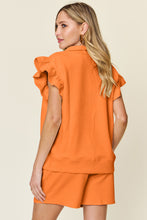 Back view of model styled in tangerine Facts Only Fit Set with flowing cap sleeves and drawstring shorts.