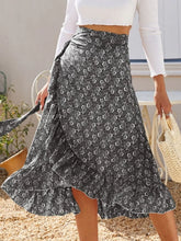 Front pose of model in Faylora Drift Skirt black, showcasing flowing ruffled hem and botanical floral print in motion