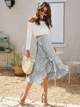 Full body pose of model in Faylora Drift Skirt gray, showcasing flowing ruffled hem and botanical floral print in motion