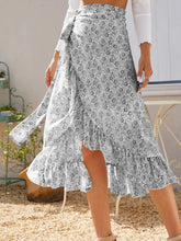 Faylora Drift Skirt front view in gray botanical print with side tie waist and asymmetric ruffled hem