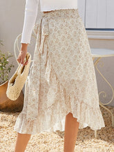 Faylora Drift Skirt front view in pastel yellow botanical print with side tie waist and asymmetric ruffled hem