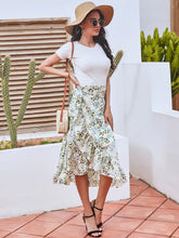 Full body side pose of model in Faylora Drift Skirt gum leaf showcasing asymmetric ruffle hem and side tie waist