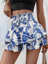 Side angle view of blue Floryza shorts with layered ruffle detail.