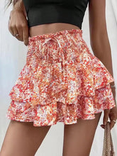 Front view of bright orange floral Floryza BloomLayer Shorts.