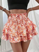 Side view of orange floral ruffle shorts with soft pleats.