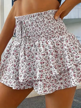 Side angle view of white Floryza shorts with airy layered detail.