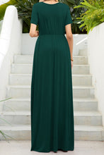 Back view of a model highlighting the forest green Blissurella Maxi Tee Dress styled with dainty gold accessories for a relaxed weekend look.