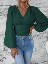 Front view of the dark green Balloonique™ Blouse highlighting smocked neckline and balloon sleeves, paired with light blue washed jeans, and jewelry.