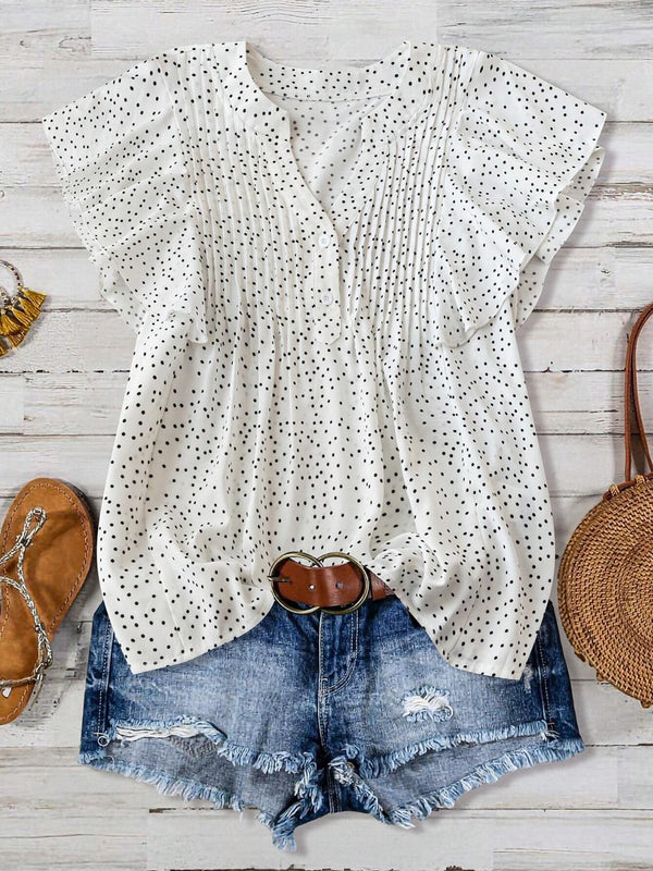 Front view of EverDot Flutter Top in white polka dot with flutter sleeves paired with earrings, belt, brown sandals, and straw handbag in a flat lay photo.