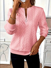 a woman modeling the blush pink Sunset Coastal Bliss Texture Half Zip Long Sleeve Sweatshirt paired with jewelry, and dark blue denim jeans while taking a selfie photo at the studio