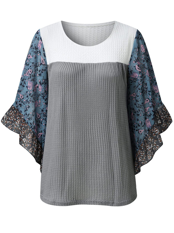 Front view of the BlossomEase Blouse in gray to show floral sleeves and ruffle trim.