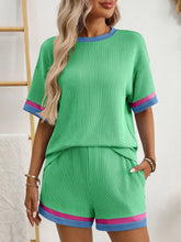 Model laughing with friends in Glowthentic™ Green set at an outdoor event.