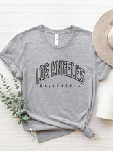 CaliVista Tee in gray paired with straw hat in flat lay, styled for casual summer outfit inspiration.