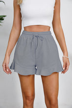Model wearing gray Plus Size Drawstring Ruffle Hem Shorts showing relaxed fit and tie-front waist.