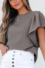 Model styled in a gray RuffleRidge Top with a white shorts, sandals, and accessories for a complete look.