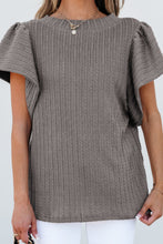 Close-up of the rope-like textured fabric and sleeve detail. on a gray RuffleRidge Top.
