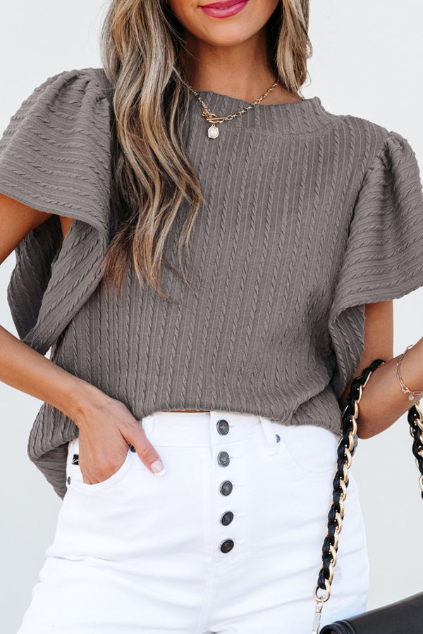 Model styled in a gray RuffleRidge Top with a white denim skirt, heels, and accessories for a complete look.