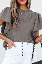 Model styled in a gray RuffleRidge Top with a white denim skirt, heels, and accessories for a complete look.