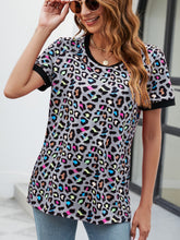 Model wearing a gray dawn leopard print round neck short sleeve tee, paired with black jeans and sneakers for a laid-back, everyday style.