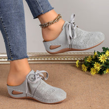 Model showcasing the sides of a pair of the grey Lace-Up Round Toe Wedge Sandals and a gold anklet and blue jeans.