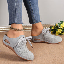 side view of grey Lace-Up Round Toe Wedge Sandals and a gold anklet and blue jeans showcasing perforation detail.