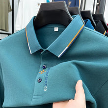 Close-up front view of green Royale Crest Fleur de Lis Polo showing embroidered placket detail.