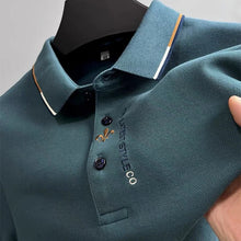 Zoomed in front view of green Royale Crest Fleur de Lis Polo showing quality fabric texture.