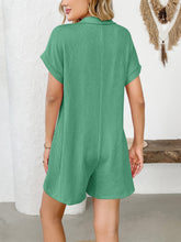 Rear view of green romper with model's hand in back pocket.