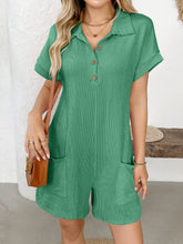 Front-facing view of model in green romper under natural sunlight.