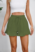Model in green Plus Size Drawstring Ruffle Hem Shorts featuring playful ruffle trim and adjustable waist.