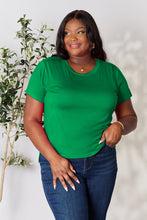 Model smiling in vibrant green solid short sleeve t-shirt