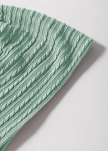 A close up photo of the fabric quality and ribbed texture of a gumleaf Round Neck Flounce Sleeve Blouse.